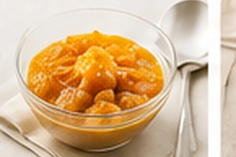 A small bowl of soft, pale apple compote dusted with a little cinnamon.