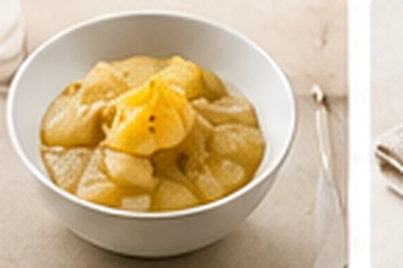 A small bowl of soft cooked pear compote with a hint of vanilla.